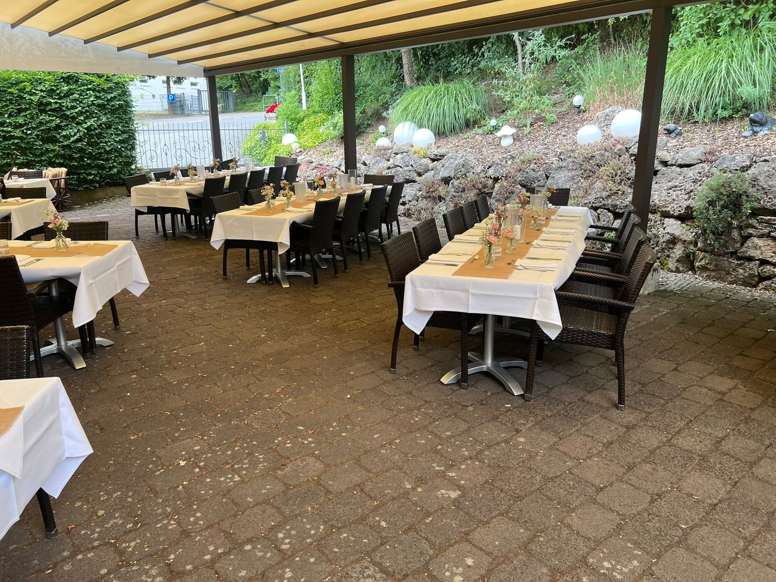 Überdachte Terrasse im Biergarten des Hessischen Hof mit festlich eingedeckten Tischen